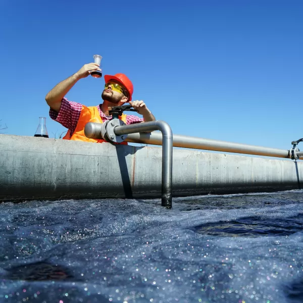 Ingenieure_kontrollieren_in_Abwasserbehandlungsanlage_einen_Tank_mit_Belüftungsanlage